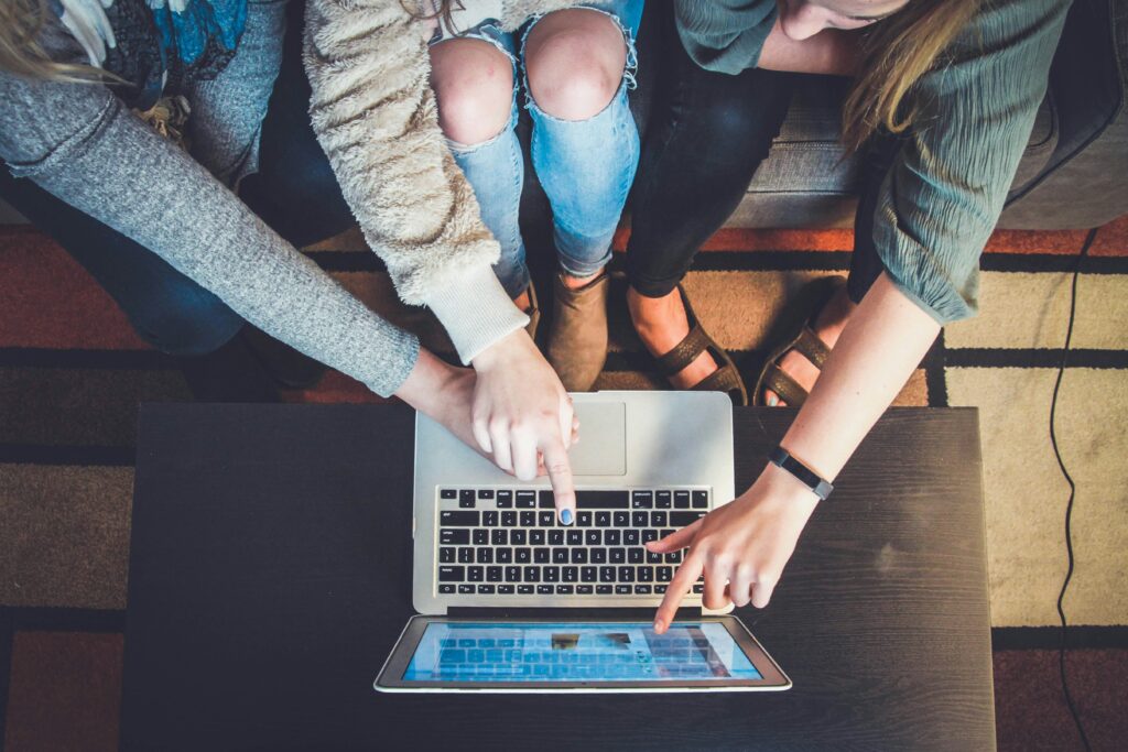 People pointing out to a Mac screen